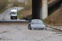 A car is stuck in flood water under the A11 on the Hargham Road during Storm Franklin. Byline: Sonya Duncan