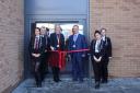 Headteacher Chanel Oswick and Clinton Gillett with pupils poised to cut the ribbon to open the school's new block