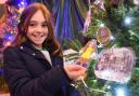 Lillie-Mae Vyse, nine, with a picture of herself on the Centenatree by the 1st Beccles Brownies at the 2021 Hungate Church Christmas tree festival in Beccles, as the pack celebrated their centenary.