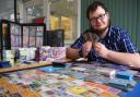 Reece Tackley with his collection of cards, sat in Beccles Library