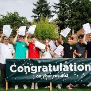 Langley students wave their results gleefully.