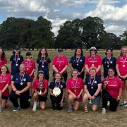 Bungay in blue while Beccles are in pink - both teams congregate to smile with the cup and shield after their victories.