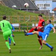 Alex Shreeve (in red) lobs the keeper for Bungay's only goal on Saturday.