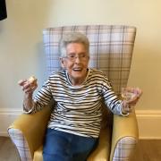 Highfield House resident Judy enjoys a drink at the home's new pub.