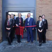 Headteacher Chanel Oswick and Clinton Gillett with pupils poised to cut the ribbon to open the school's new block