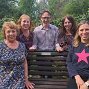 The family of John Foster with the memorial bench at Beccles Library