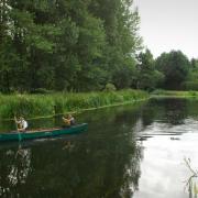A canoer on the river Waveney at Outney Meadow in Bungay